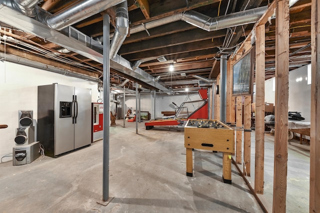 basement featuring stainless steel fridge with ice dispenser