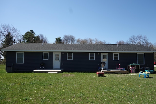 rear view of house with a deck, central AC unit, and a yard