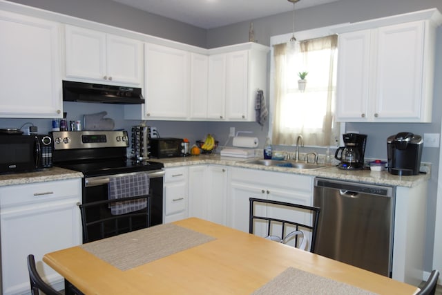 kitchen featuring white cabinetry, decorative light fixtures, appliances with stainless steel finishes, and sink