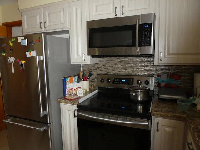 kitchen with appliances with stainless steel finishes, dark stone counters, and tasteful backsplash