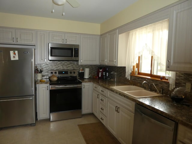 kitchen with appliances with stainless steel finishes, sink, ceiling fan, and tasteful backsplash