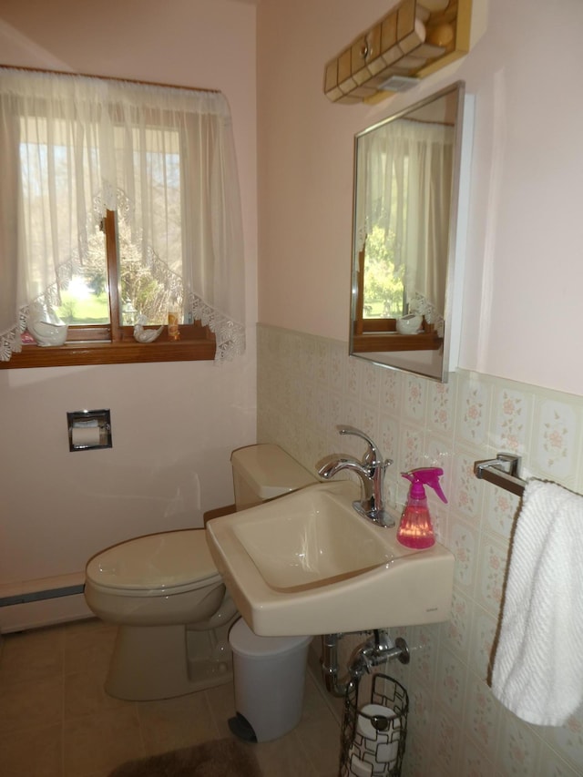 bathroom featuring tile flooring, sink, toilet, and a baseboard heating unit