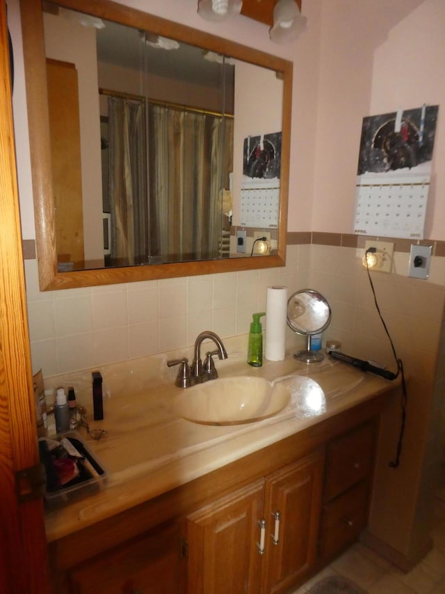 bathroom featuring backsplash and vanity with extensive cabinet space