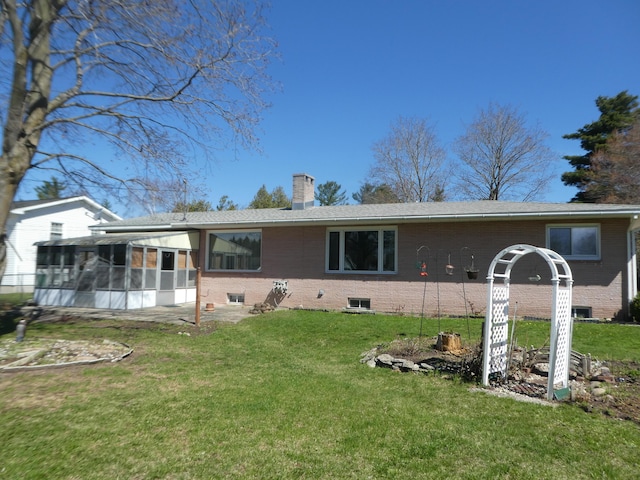 view of front of house with a front yard and a sunroom