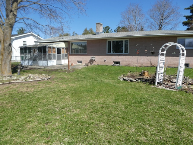 back of house with a sunroom and a yard