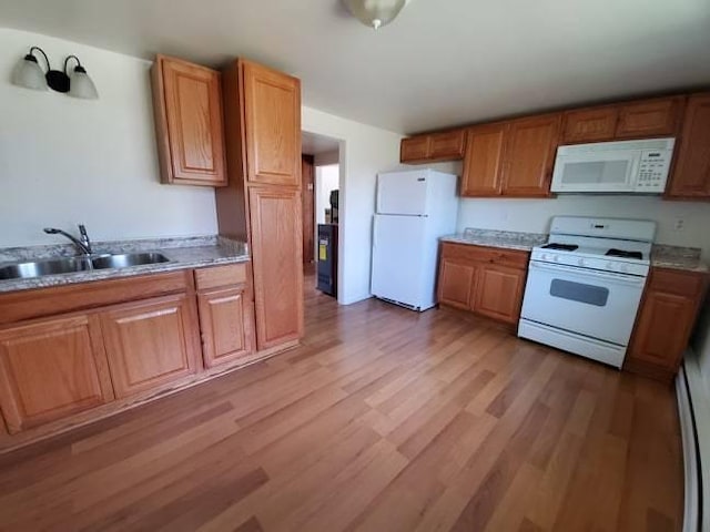 kitchen featuring white appliances, sink, and light hardwood / wood-style flooring