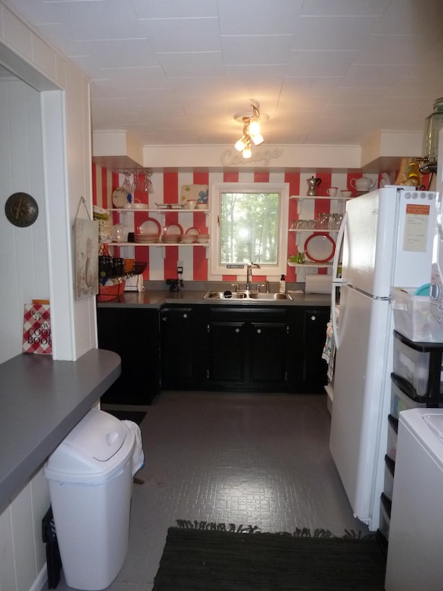 kitchen featuring dark tile floors, white fridge, and sink