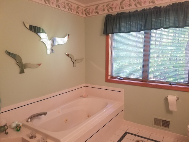 bathroom featuring tile floors, a healthy amount of sunlight, and a bath to relax in