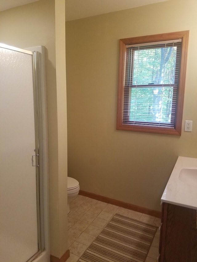 bathroom with a shower with shower door, tile flooring, toilet, and vanity