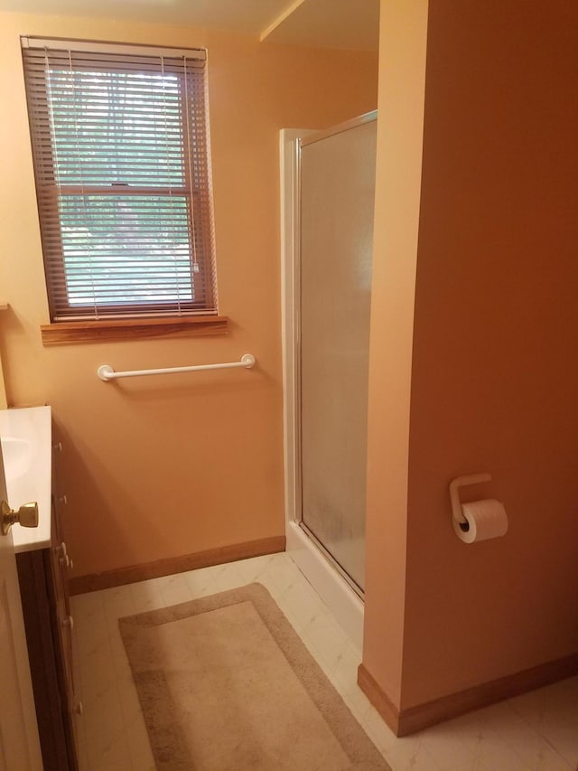 bathroom with an enclosed shower, vanity, and tile floors