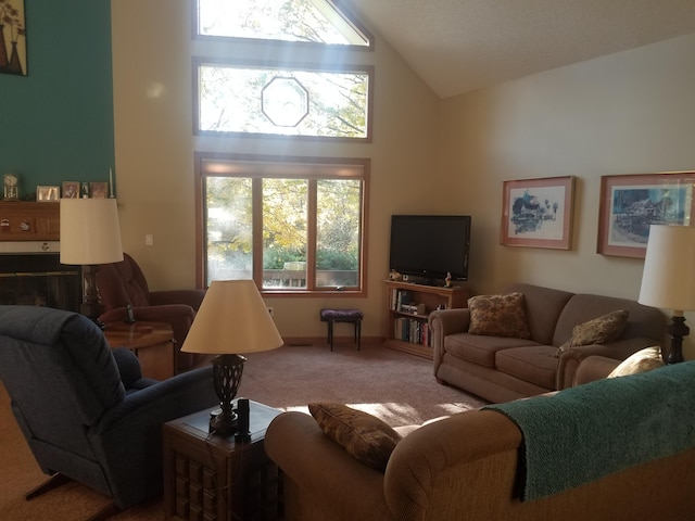 living room with high vaulted ceiling, a wealth of natural light, and carpet floors