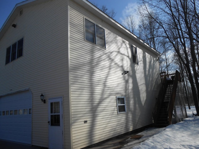 snow covered property with a garage