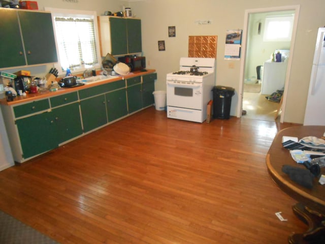 kitchen with white gas range and hardwood / wood-style flooring