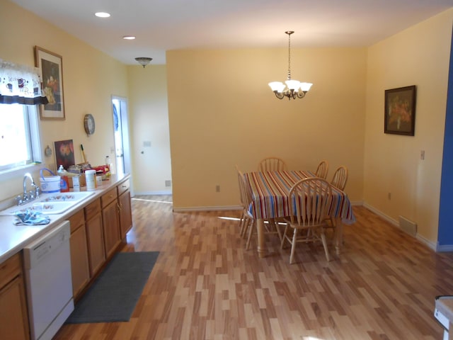 dining area featuring a chandelier, light hardwood / wood-style flooring, and sink