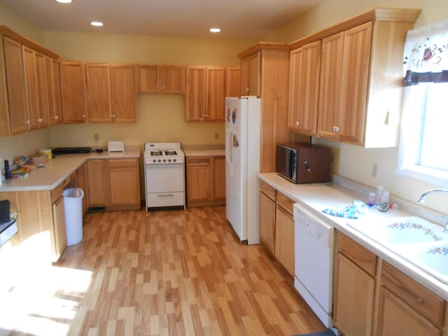 kitchen with white appliances, sink, and light hardwood / wood-style flooring