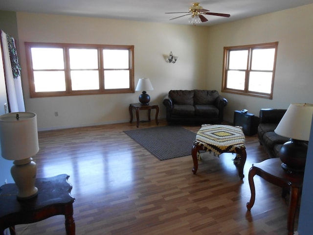 living room with a healthy amount of sunlight, ceiling fan, and dark wood-type flooring