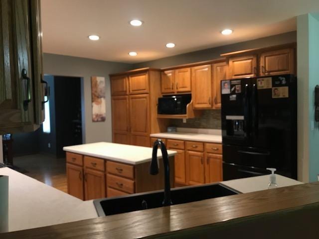 kitchen with sink, tasteful backsplash, and black appliances