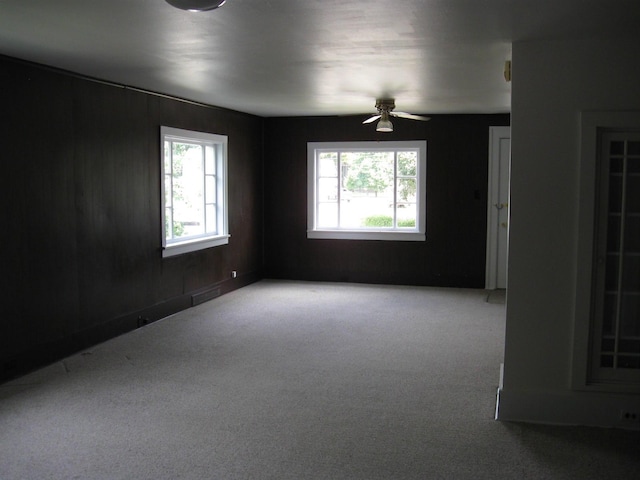 empty room with dark colored carpet and ceiling fan