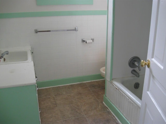 bathroom featuring vanity, tile floors, toilet, and tile walls