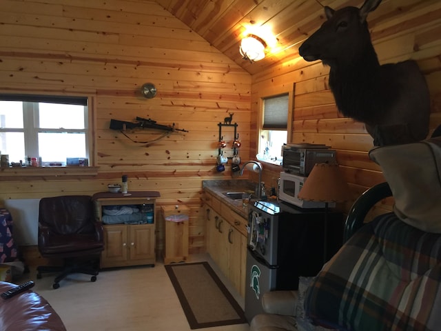 kitchen featuring wooden ceiling, wood walls, sink, and vaulted ceiling