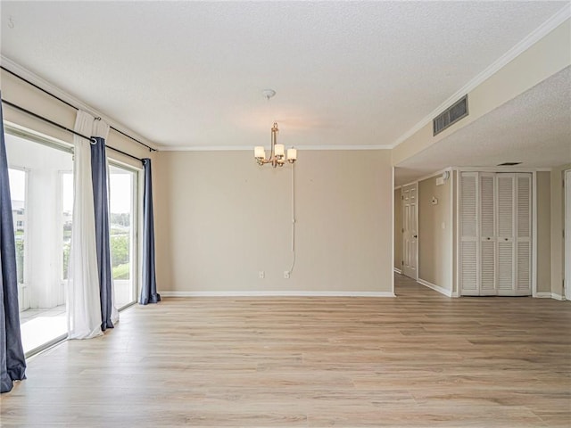 unfurnished room featuring a notable chandelier, crown molding, a textured ceiling, and light hardwood / wood-style flooring