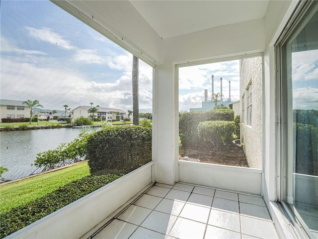 sunroom featuring a water view