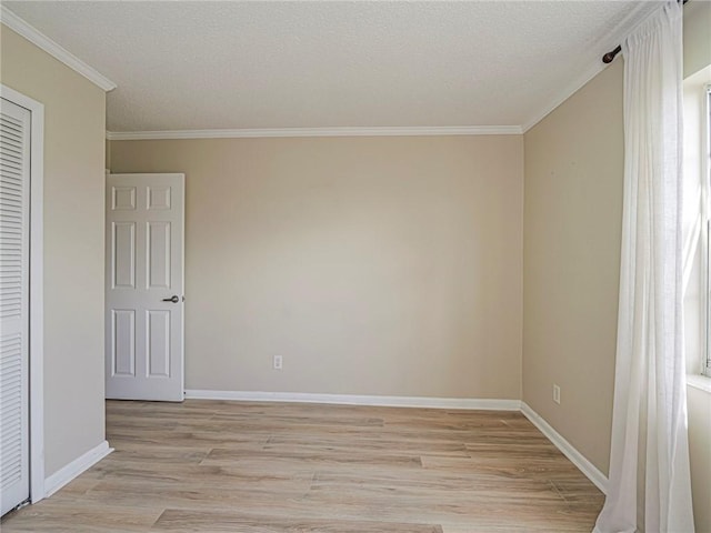 unfurnished room featuring a textured ceiling, light hardwood / wood-style flooring, and crown molding