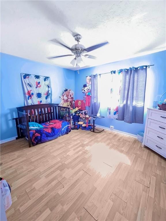 bedroom featuring a textured ceiling, light hardwood / wood-style flooring, and ceiling fan