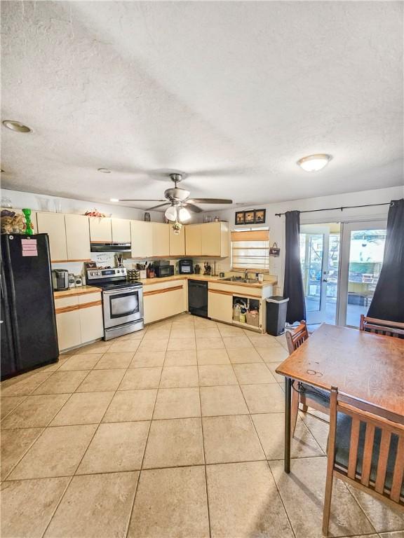 kitchen with light tile patterned floors, sink, ceiling fan, black appliances, and a textured ceiling