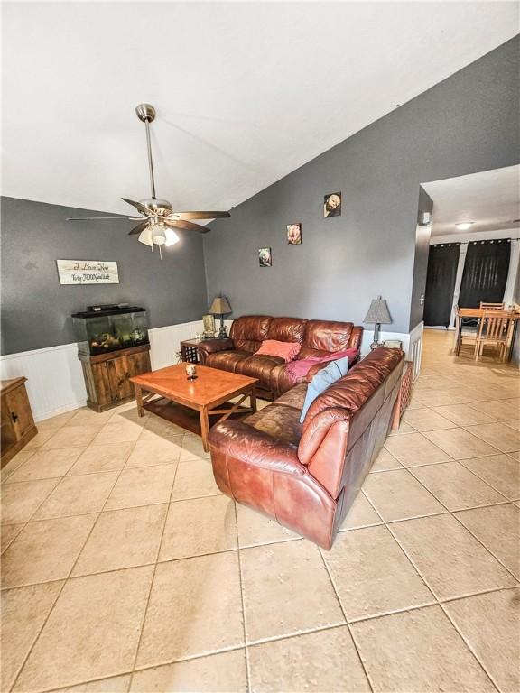 tiled living room featuring vaulted ceiling and ceiling fan