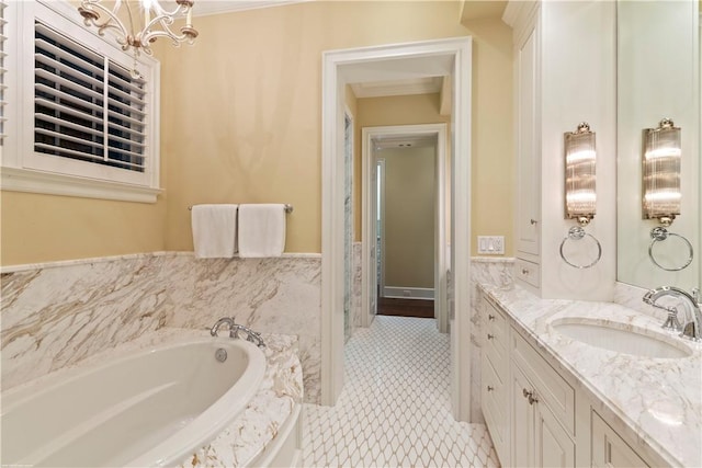 full bath with a wainscoted wall, vanity, ornamental molding, a chandelier, and a garden tub
