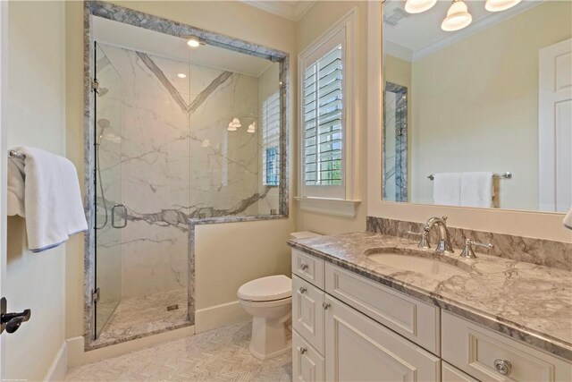 bathroom with a marble finish shower, crown molding, vanity, and toilet