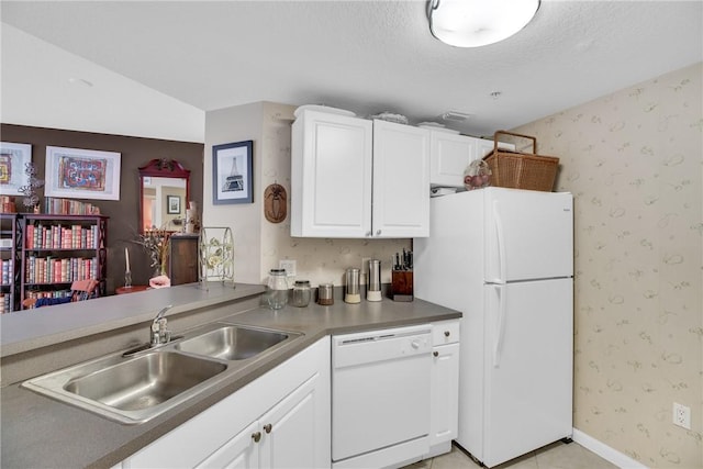 kitchen with white appliances, sink, light tile patterned floors, a textured ceiling, and white cabinetry