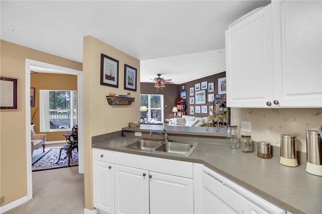 kitchen with ceiling fan, dishwasher, sink, light colored carpet, and white cabinets