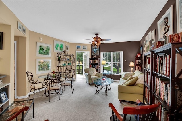 carpeted living room with ceiling fan