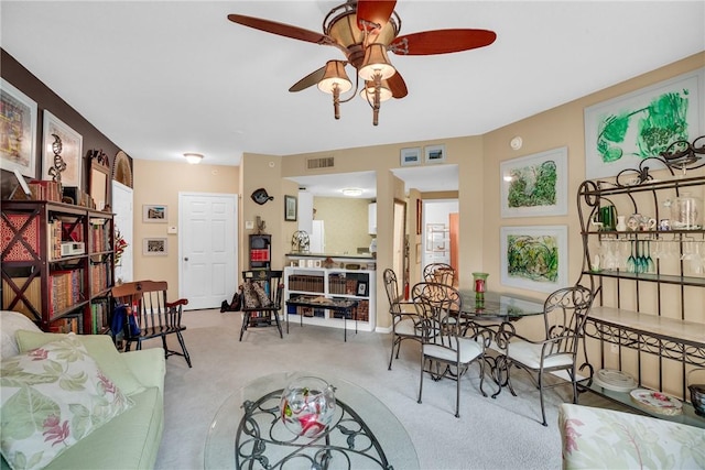 carpeted dining space with ceiling fan