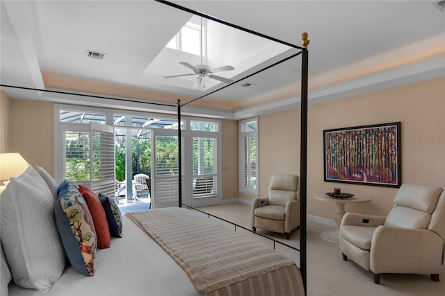 carpeted bedroom with a raised ceiling and access to outside