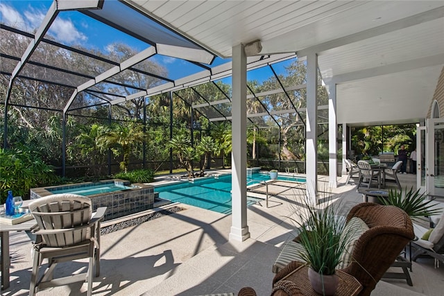 view of swimming pool featuring a lanai, a patio area, and an in ground hot tub