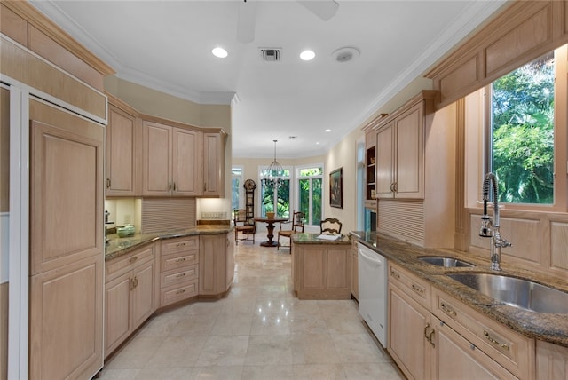 kitchen featuring pendant lighting, dishwasher, sink, dark stone counters, and kitchen peninsula