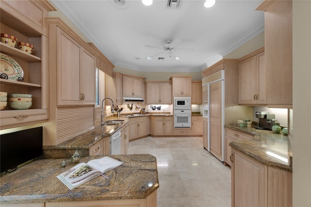 kitchen with stone countertops, sink, light brown cabinetry, and white appliances