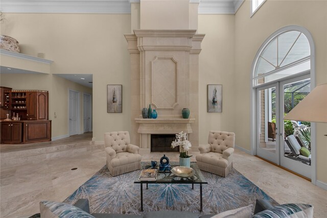 living room with a high ceiling, ornamental molding, and french doors