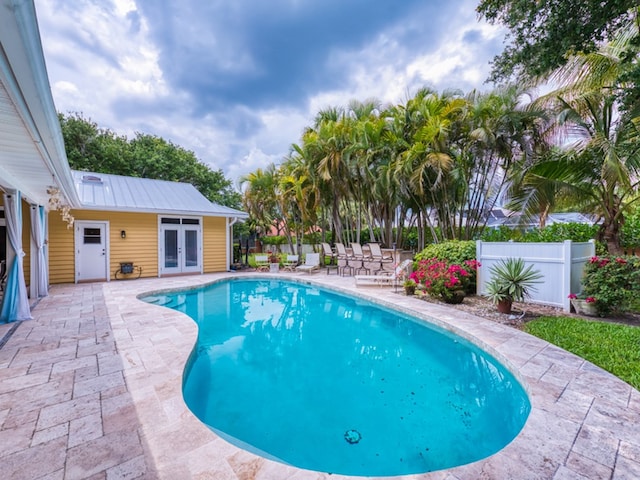 view of swimming pool featuring a patio and french doors