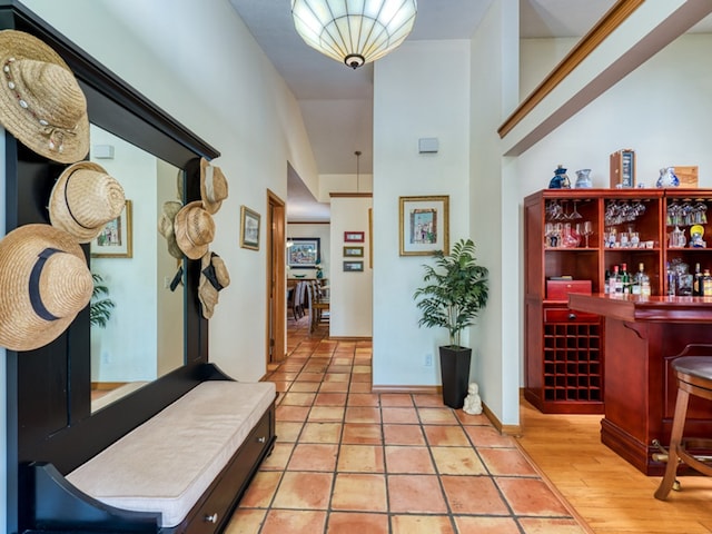 hallway featuring a towering ceiling and light wood-type flooring