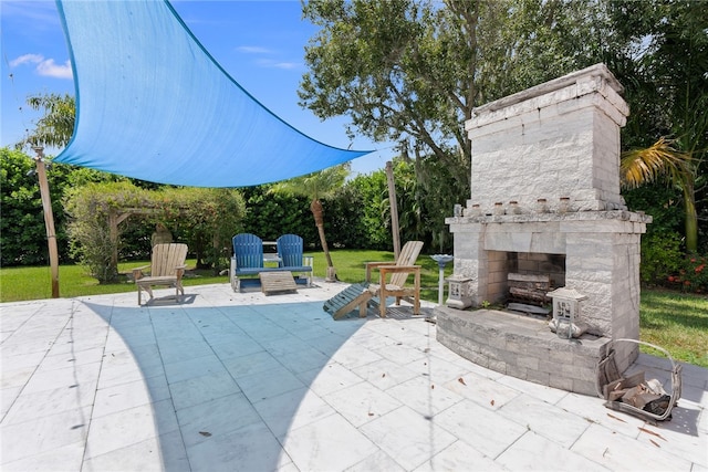 view of patio featuring an outdoor stone fireplace