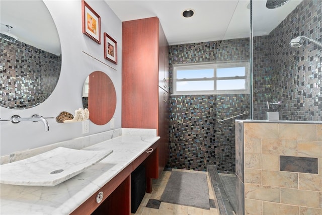 bathroom with vanity and a tile shower