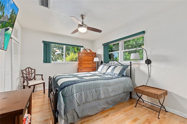 bedroom with a closet, light wood-type flooring, and ceiling fan