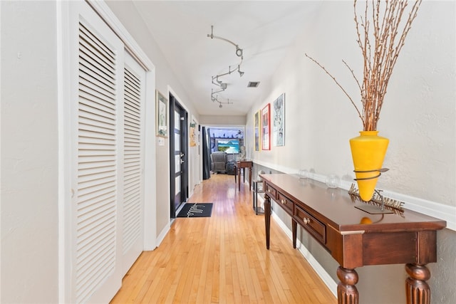 hall with track lighting and light hardwood / wood-style floors