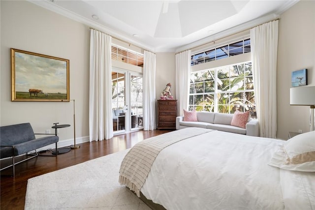 bedroom with crown molding, access to outside, dark hardwood / wood-style flooring, a raised ceiling, and ceiling fan