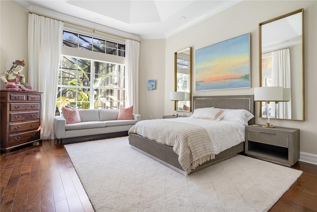 bedroom with crown molding, dark hardwood / wood-style floors, and a raised ceiling