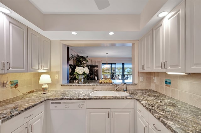 kitchen with dishwasher, stone counters, white cabinets, sink, and tasteful backsplash